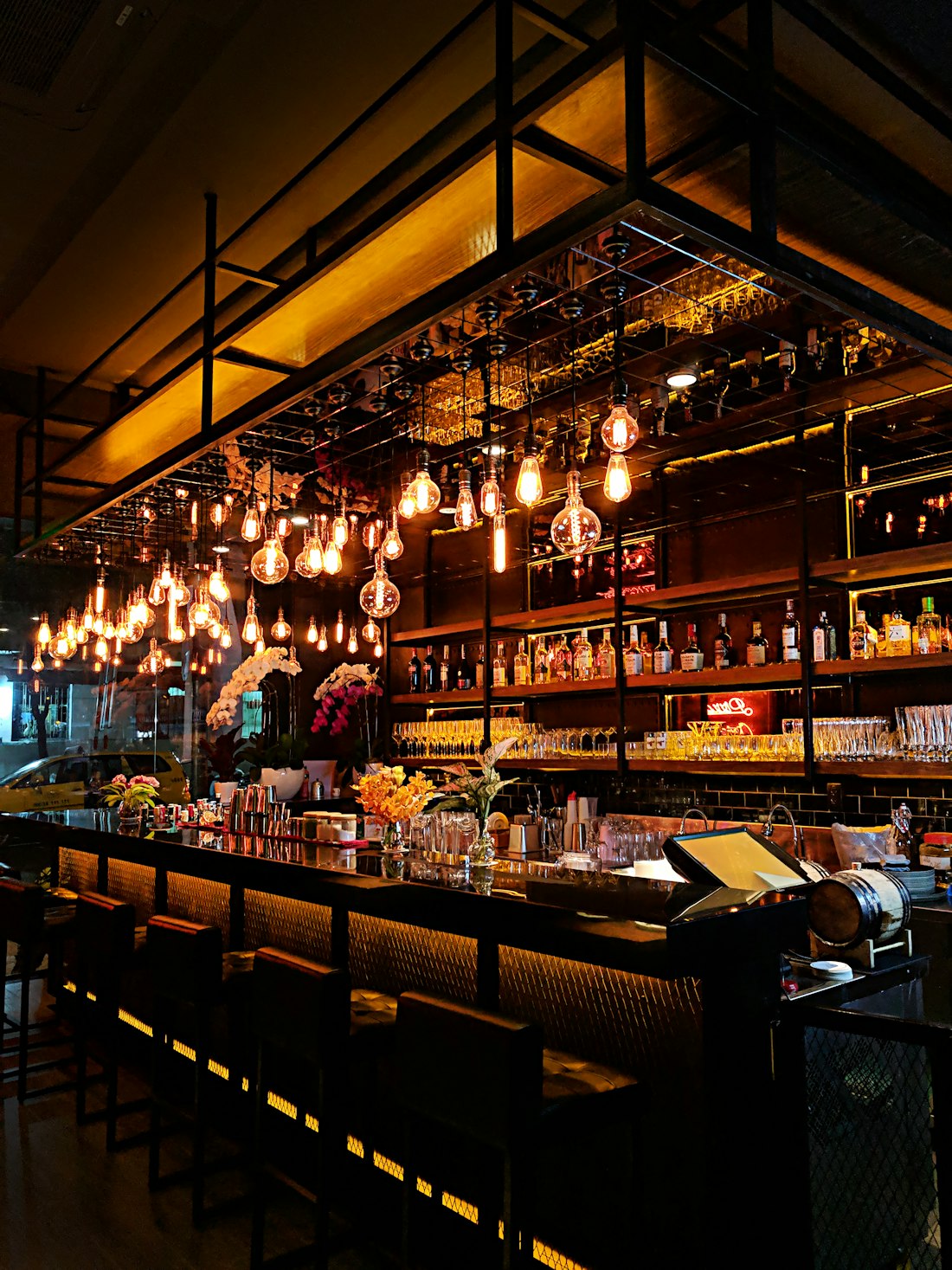 Bar stools under the glow, seats waiting
